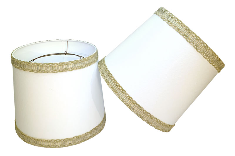 Lampshades refurbished for antique lamps in white linen fabric with the original wire frame fitters and braids.